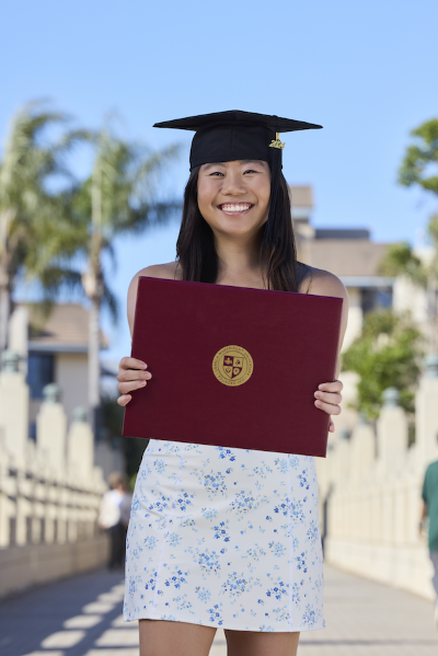 Iliana Chen outside holding diploma
